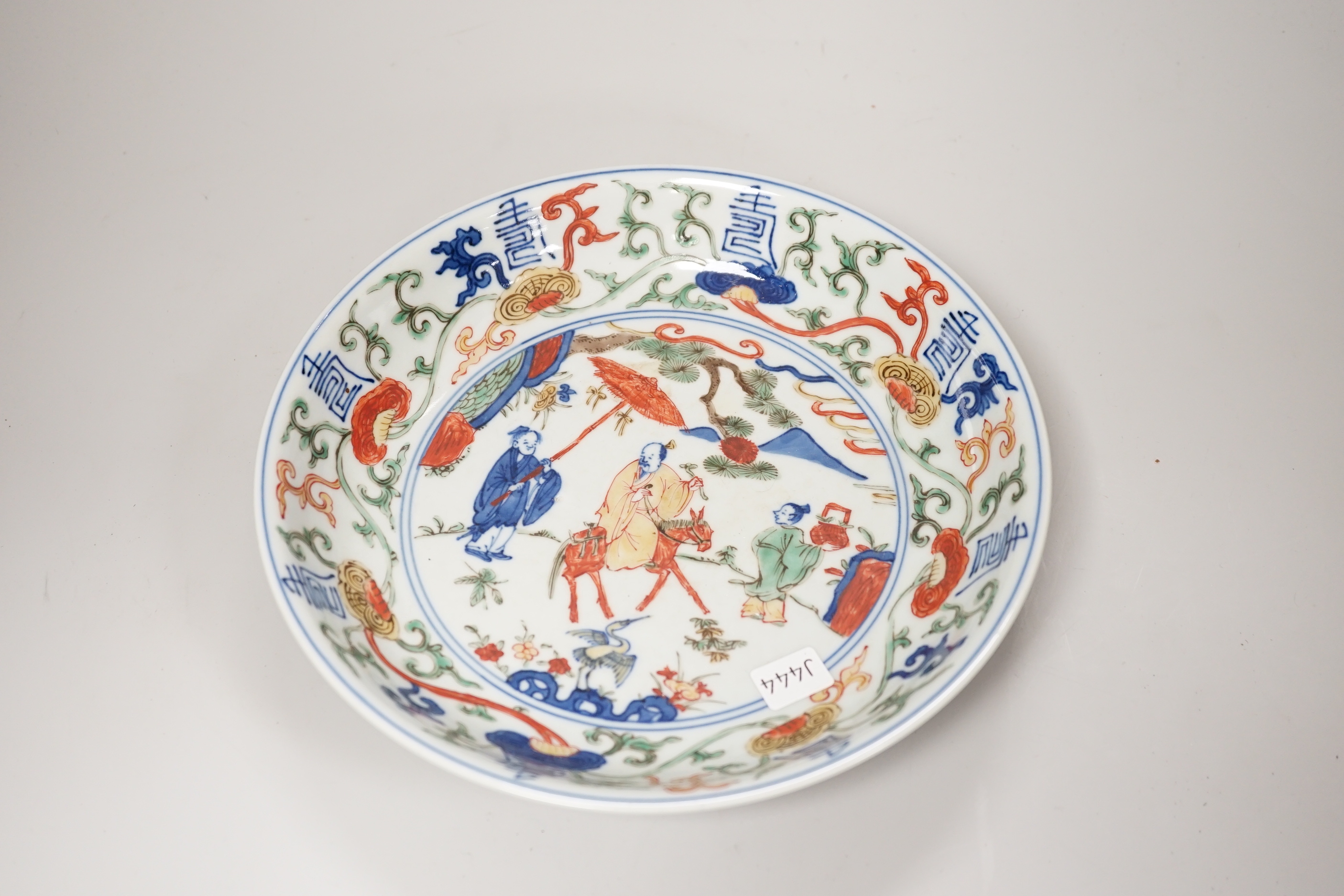 A Chinese wucai shallow dish hand painted with figures and flowers, housed in a fitted case, 23cm in diameter